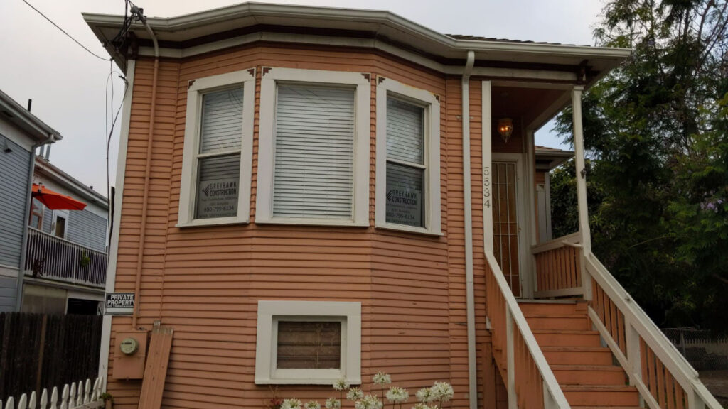 Peach-colored house with bay windows and a front porch
