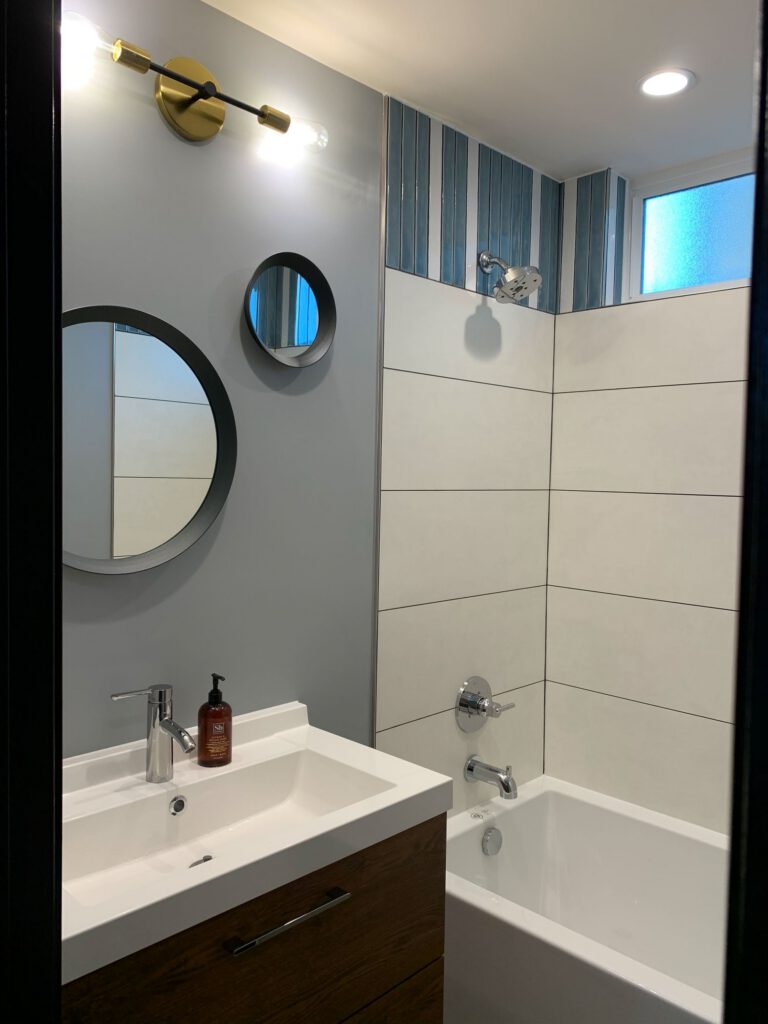 and vertical blue accent tile in the shower area.
